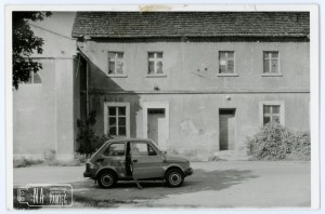 Koniec lat 80. Widok na salę gromadzką, kino kujawiak i budynek mieszkalny nr 83, naprzeciwko remizy OSP Radwanice, w samochodzie Fiat 126p siedzi Krzysztof Walacik